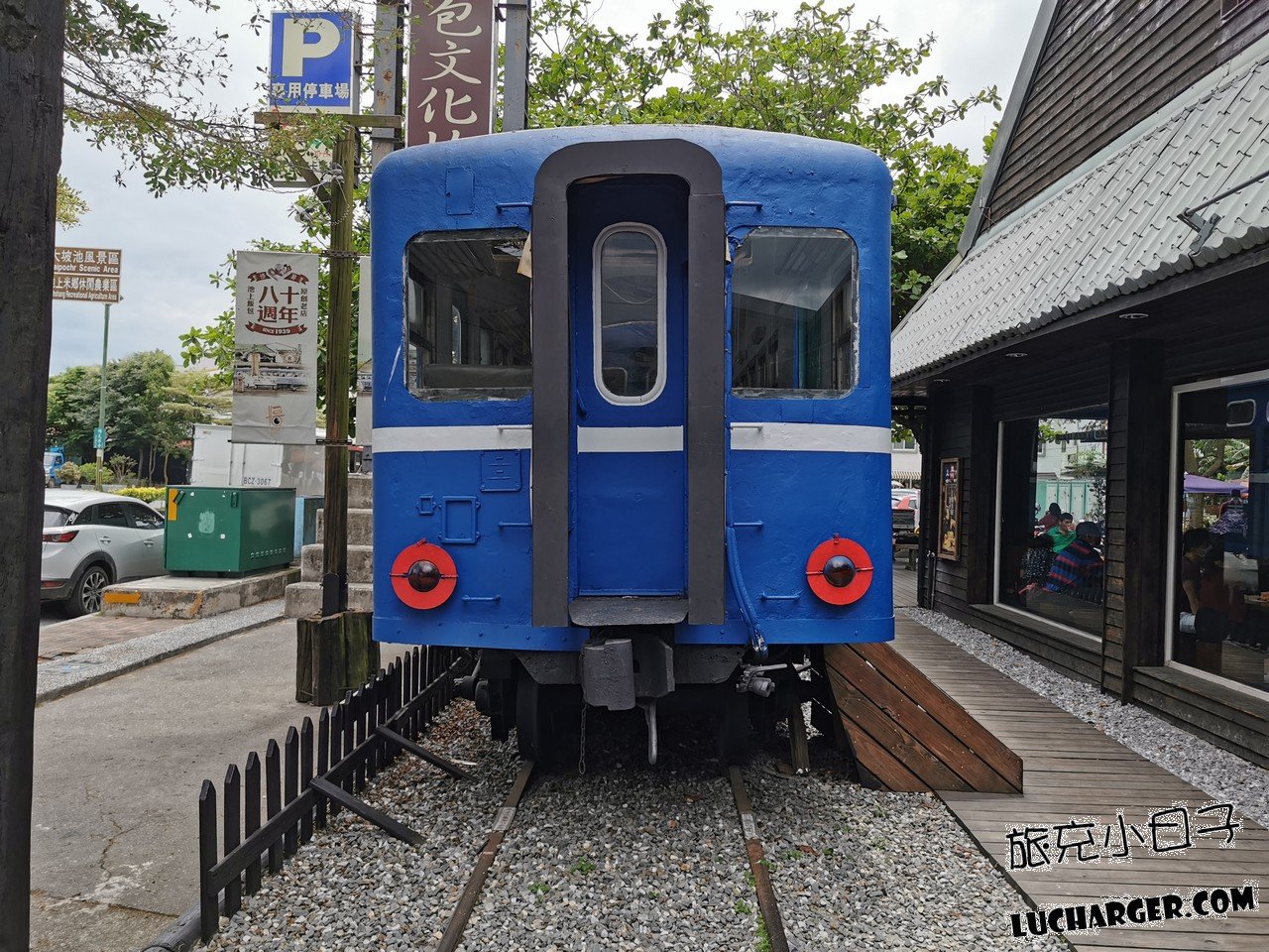 悟饕池上飯包文化故事館外側藍色火車車廂與停車場指示