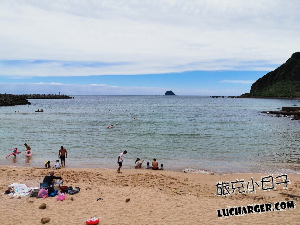 大武崙沙灘彎月形沙岸與遊客踏浪